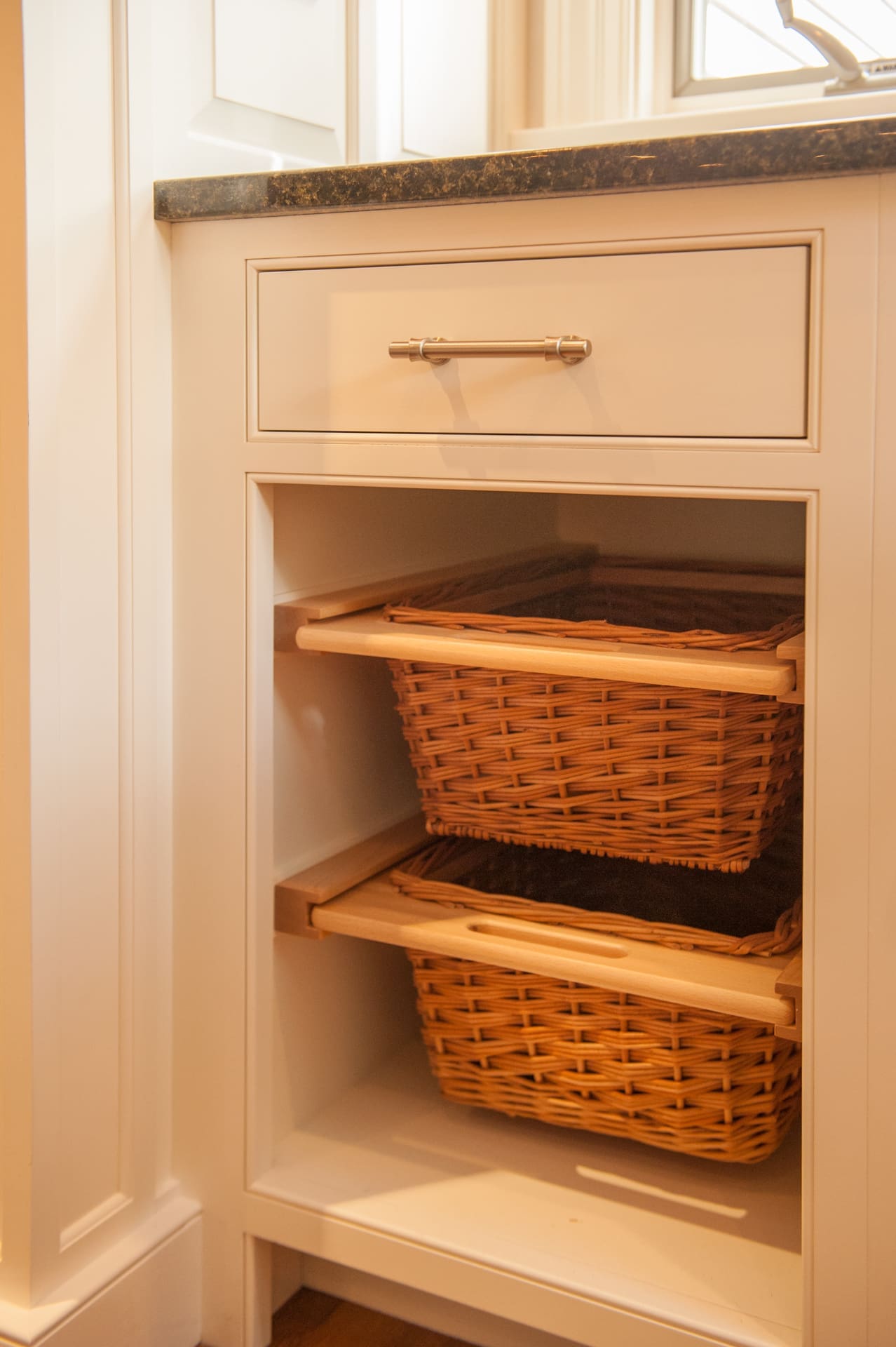 A photo of a cabinet with exposed pull-out wicker basket drawers.