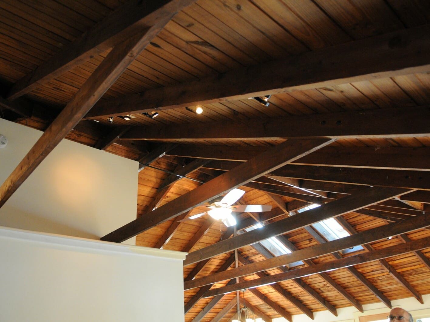 A photo of a large vaulted ceiling with supportive wooden beams.