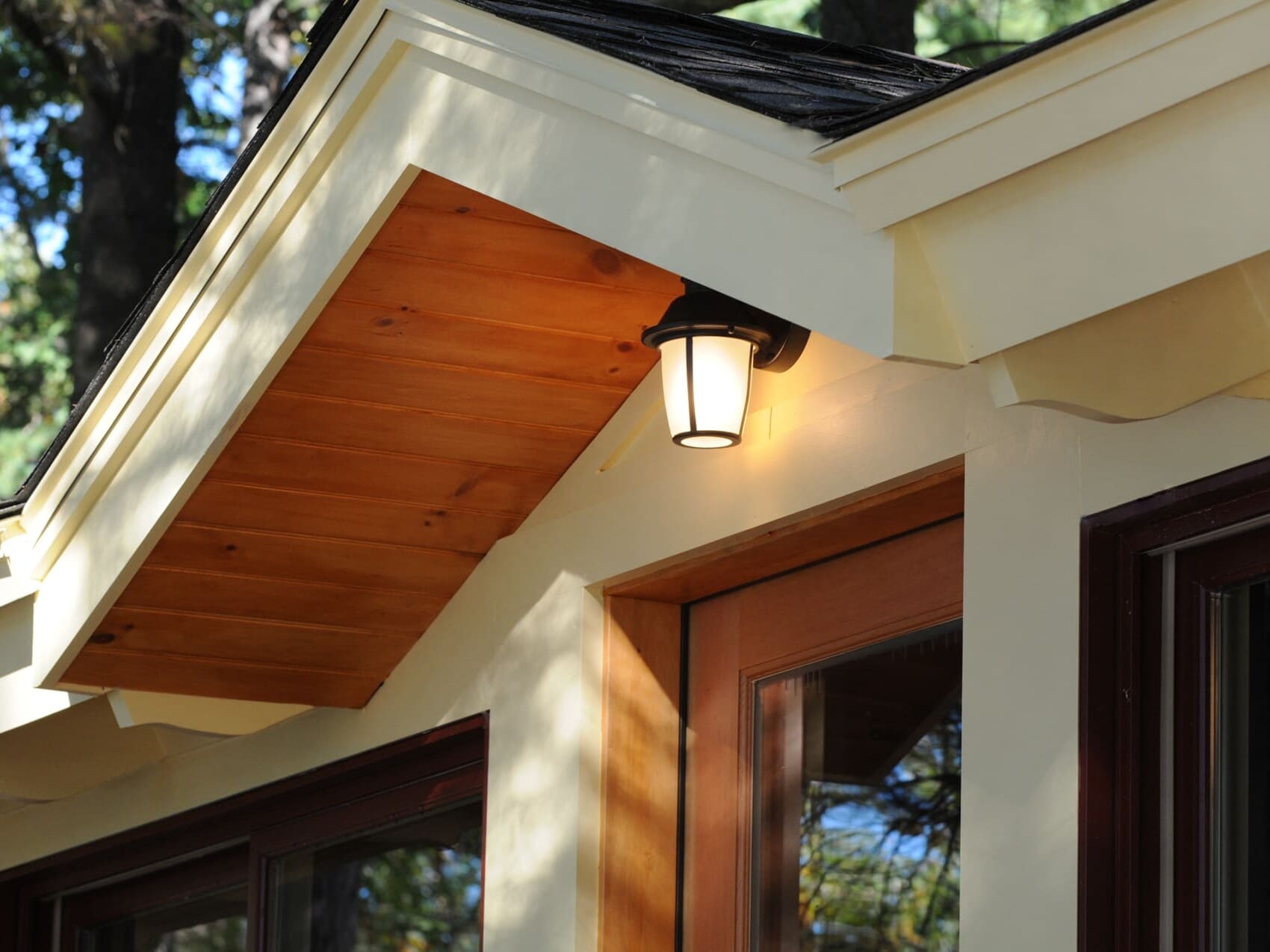 A photo of a doorway with a roof gable above it, housing a light fixture.