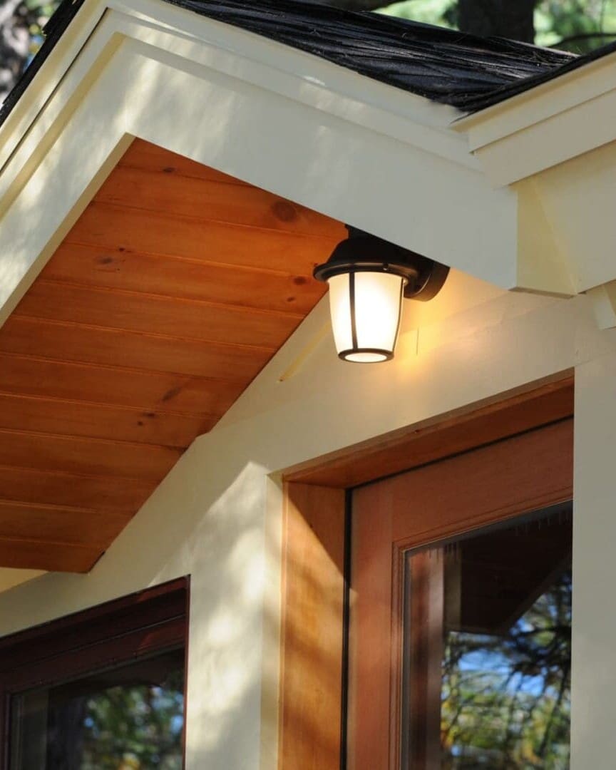 A photo of a doorway with a roof gable above it, housing a light fixture.