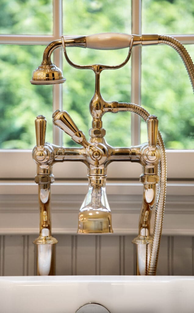 A photo of an intricate vintage-style brass tub faucet.
