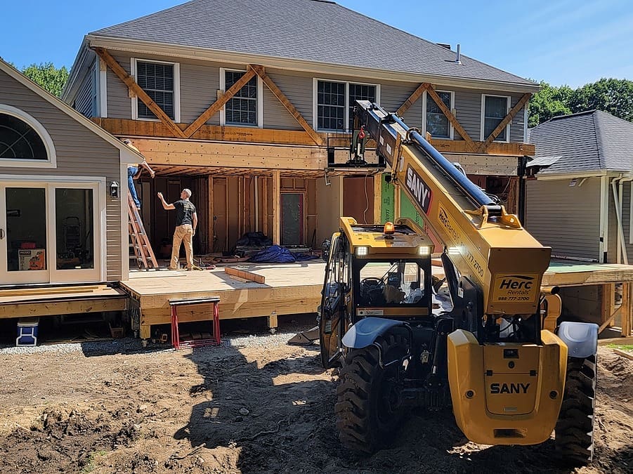 Construction work on house with heavy machinery.